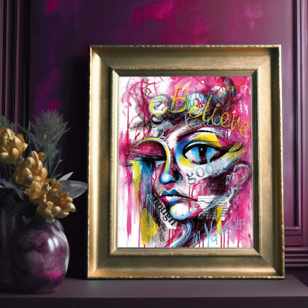Believe in Yourself abstract portrait art print with graffiti-style text, bold magenta, yellow, blue, and black colors, featuring positive affirmations and collaged criticisms.
Shown in Gold Frame
